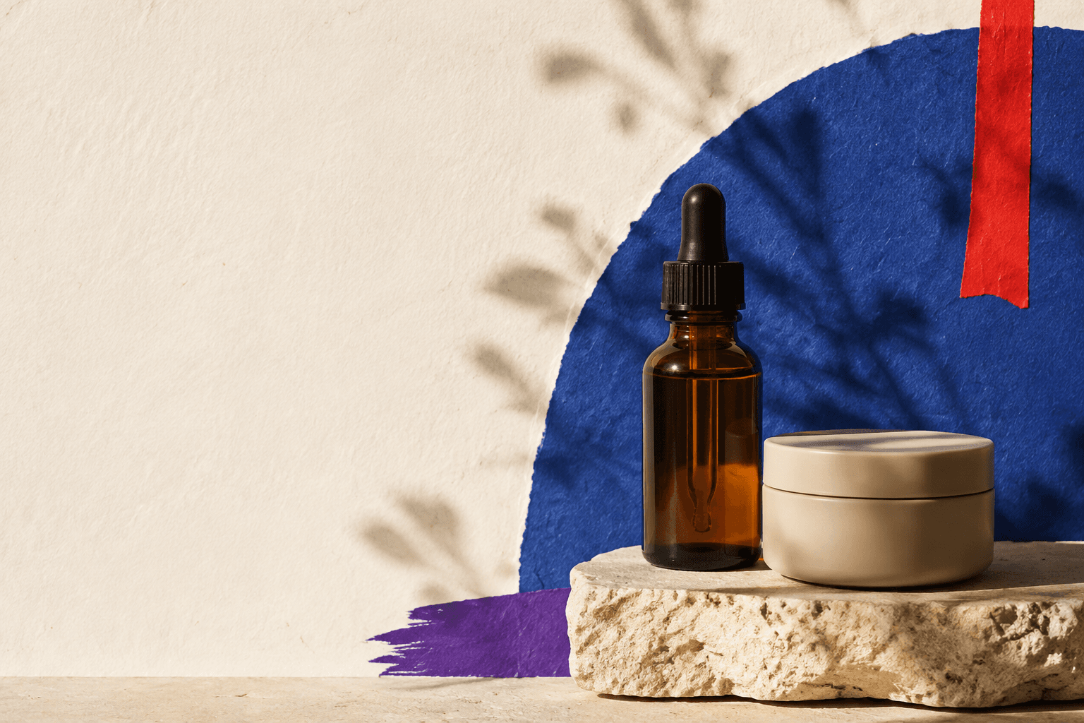 Amber serum and cream jar in a composition of blue, red and purple paper